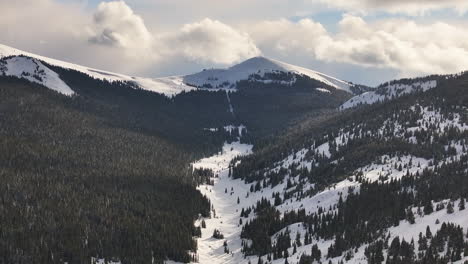 Winter-Springtime-Vail-Pass-Ptarmigan-Hill-Colorado-snowmobile-trail-cat-track-Rocky-Mountains-backcountry-high-altitude-peaks-ski-snowboard-sunset-clouds-forward-pan-reveal-motion