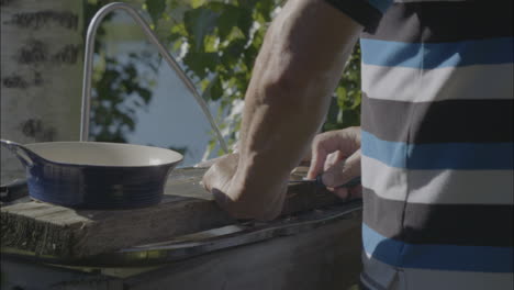 Skandinavischer-Sommer:-Männliche-Hände-Filetieren-Gefangenen-Fisch-Im-Archipel