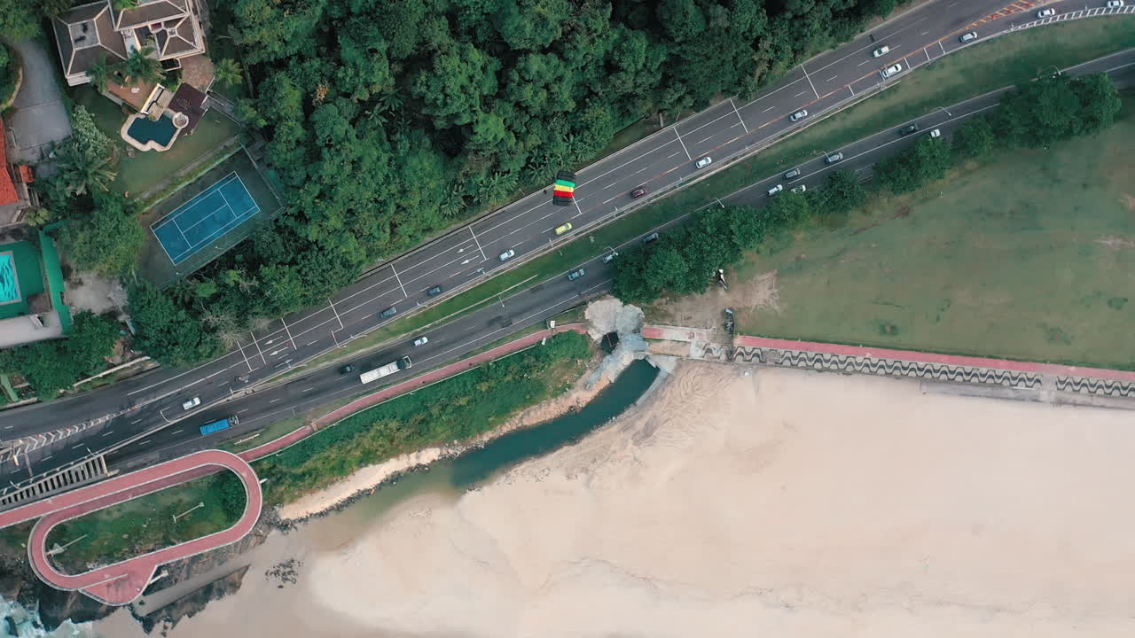 고속도로 와 주거 지역 을 가로질러 해변 으로 날아가는 낙하산 의 공중 사진