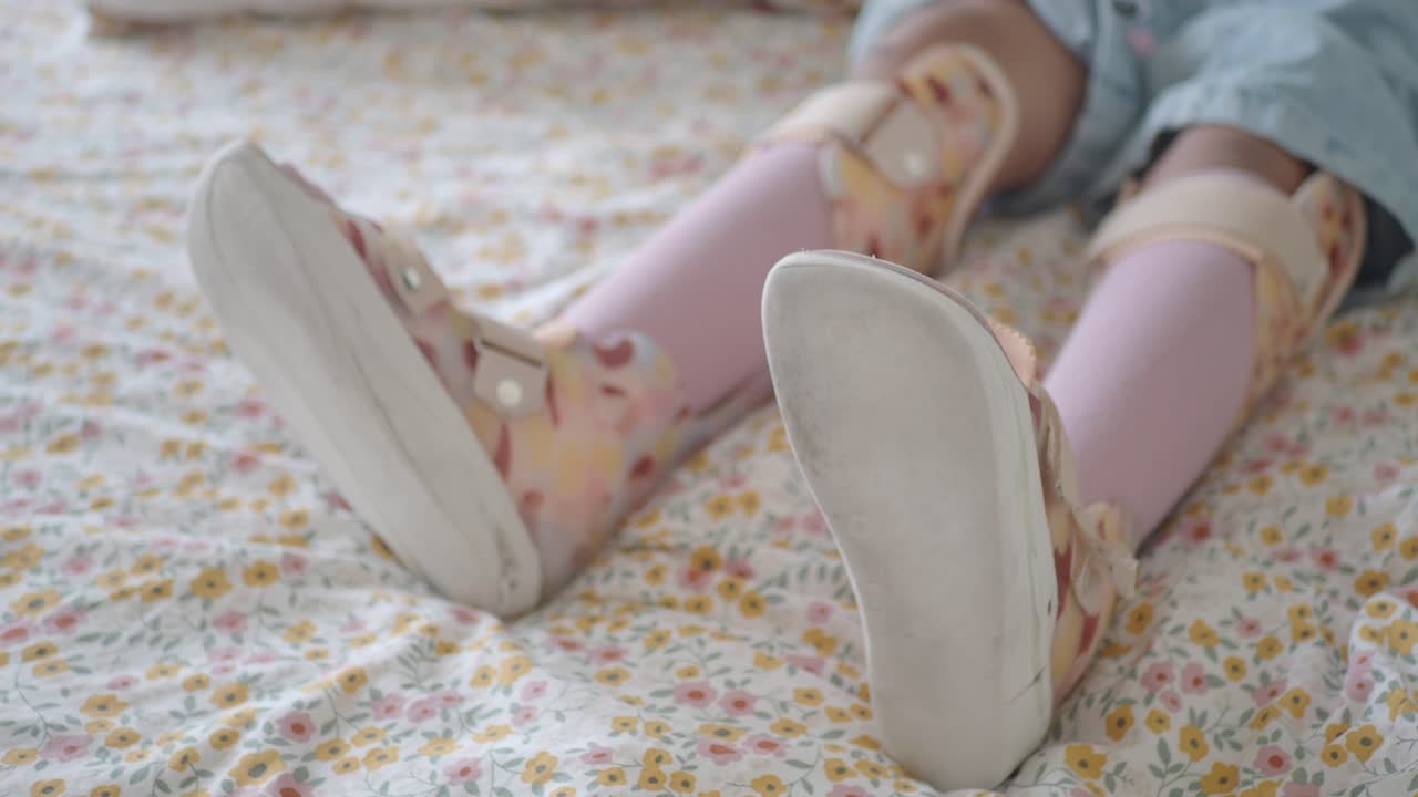 Child's Legs with Ankle-Foot Orthoses Lying on a Bed