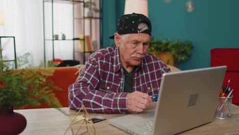 senior man shopping online with laptop
