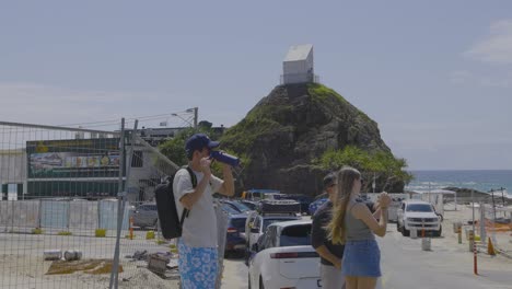 dos personas tomando fotos en la playa de currumbin