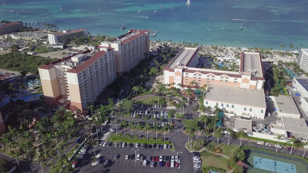 고층 호텔은 보트를 배경으로 해변을 따라 앉아 있습니다.