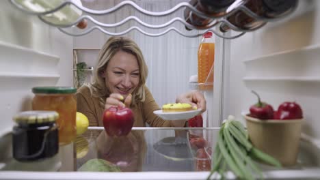 woman looking at food in refrigerator