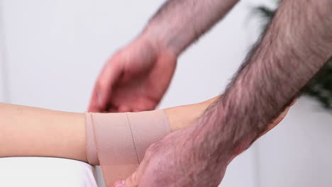 fisioterapeuta atando el tobillo de una mujer