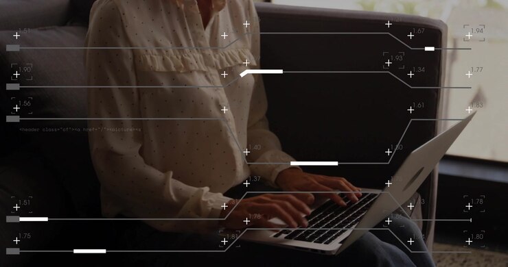 Mature adult woman typing on laptop, input activating animated code overlay for technology review