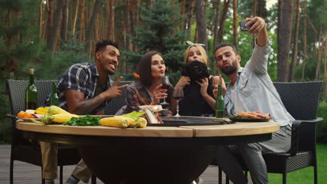 cheerful friends posing on smartphone camera in backyard