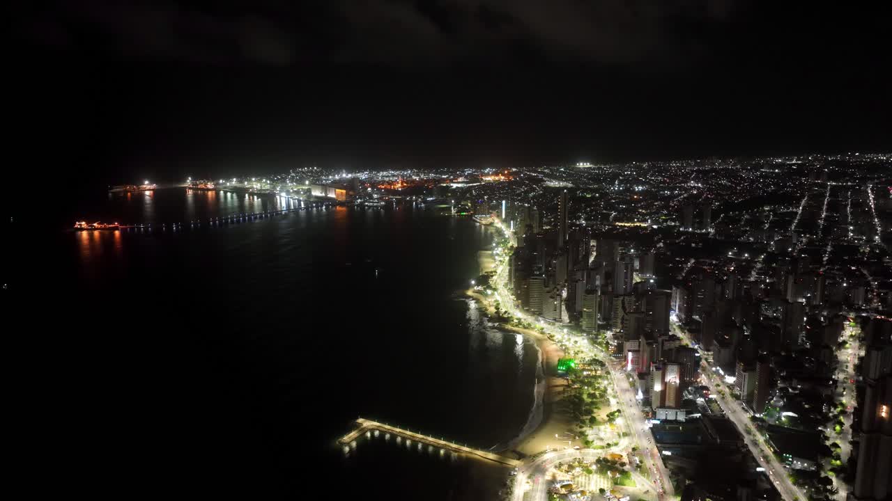 Timelapse of Fortaleza's Iracema Beach at night, showcasing city lights and ocean waves