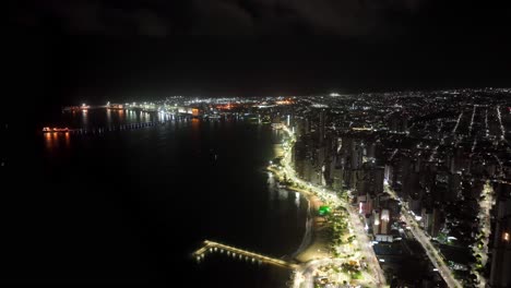 timelapse of fortaleza's iracema beach at night, showcasing city lights and ocean waves