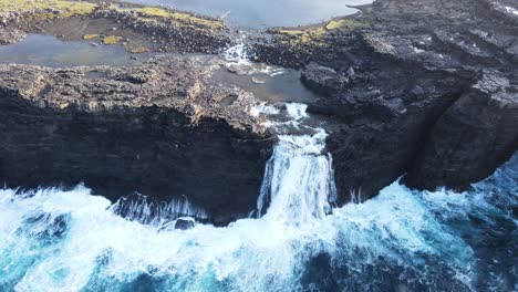 Kreisförmige-Drohnenaufnahmen-Des-Bøsdalafossur-Wasserfalls-In-Der-Nähe-Des-Leitisvatn-Sees,-Auch-Bekannt-Als-Der-Schwimmende-See,-Auf-Der-Insel-Vagar-Auf-Den-Färöer-Inseln