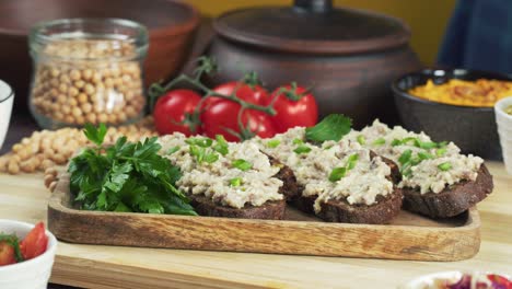 israeli cuisine. putting forshmak with black rye bread decorated with parsley close-up. national jewish herring dish, middle eastern culture. traditional snack vorschmack made of fish fillet