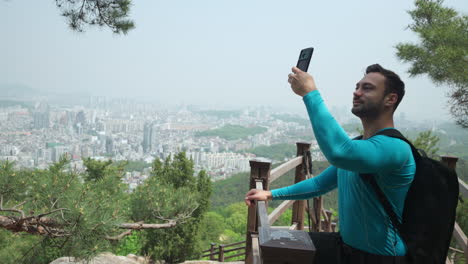 Un-Excursionista-Toma-Fotos-De-Selfie-En-Una-Ruta-De-Senderismo-De-Montaña-Con-Vistas-A-La-Ciudad-De-Seúl-En-Un-Día-Brumoso