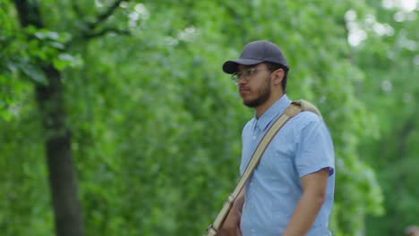 young postman walking outdoors with bag full of letters