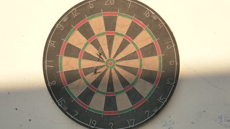 playing dart in sunny day, and the last dart hits bulls eye in last shot, 4k footage, slow motion.