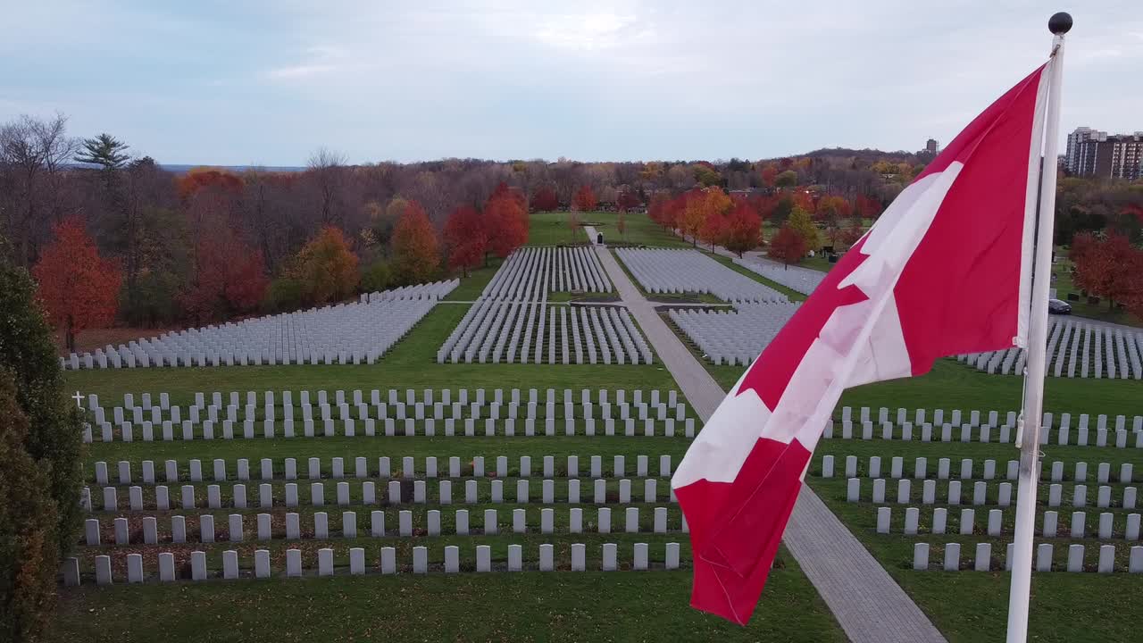 Closeup of the Canadian flag waving in a historic cemetery