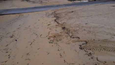 Aerial-drone-view-of-boat-ramp-on-sandy-beach-with-seabirds-in-Australia