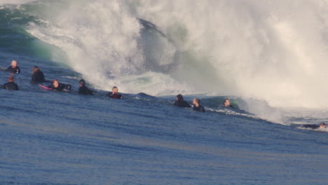 slow motion view of surfer gather in lineup as monster waves double up and crash on themselves
