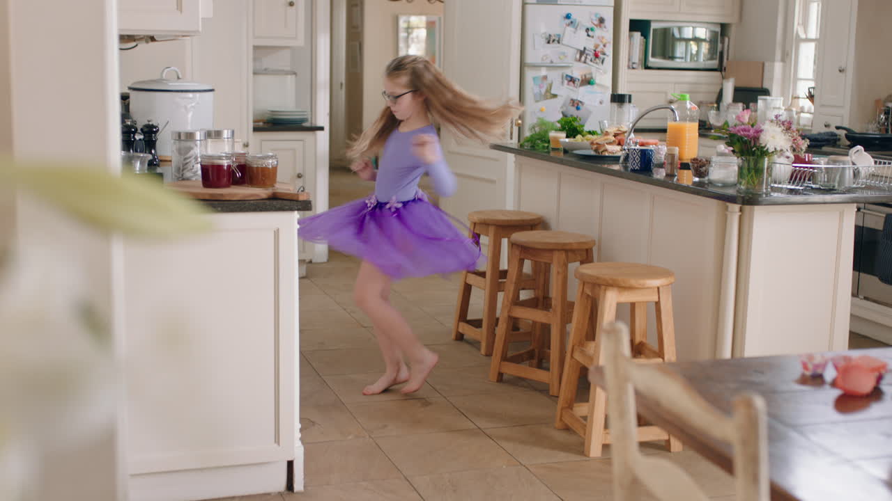 una bailarina feliz bailando en la cocina con un tutu púrpura divirtiéndose realizando movimientos de baile divertidos disfrutando de la celebración del fin de semana en casa