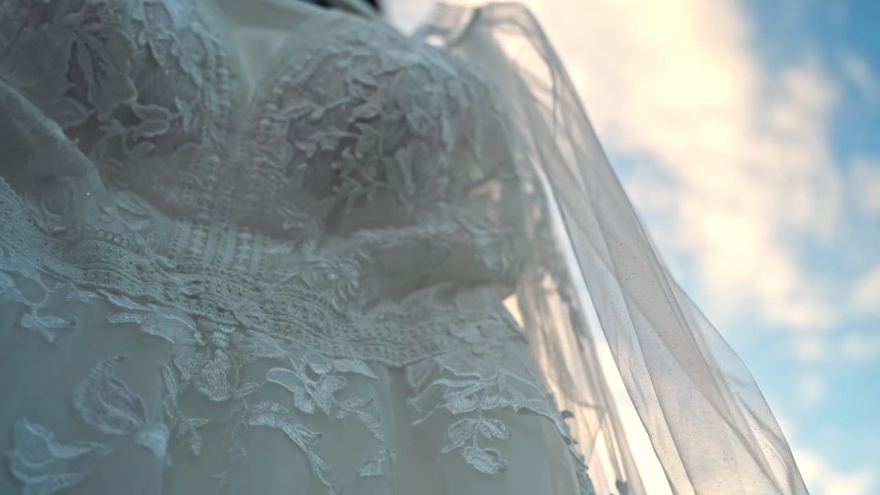 Close-up view of the bride's wedding dress on a sunny morning