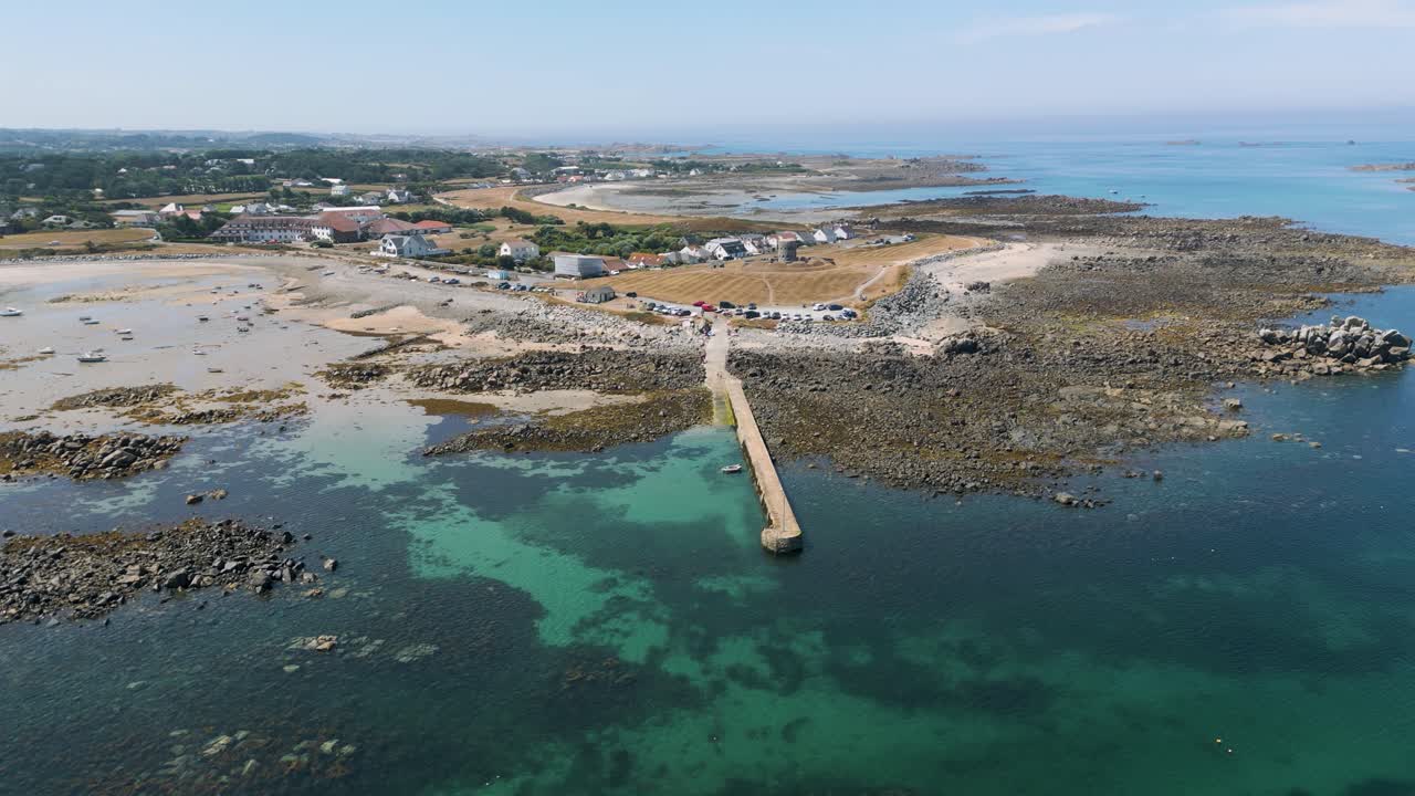 High short static drone footage over bays and promontory with crystal clear sea,boats at anchor, causeway, Martello tower and stunning golden beaches