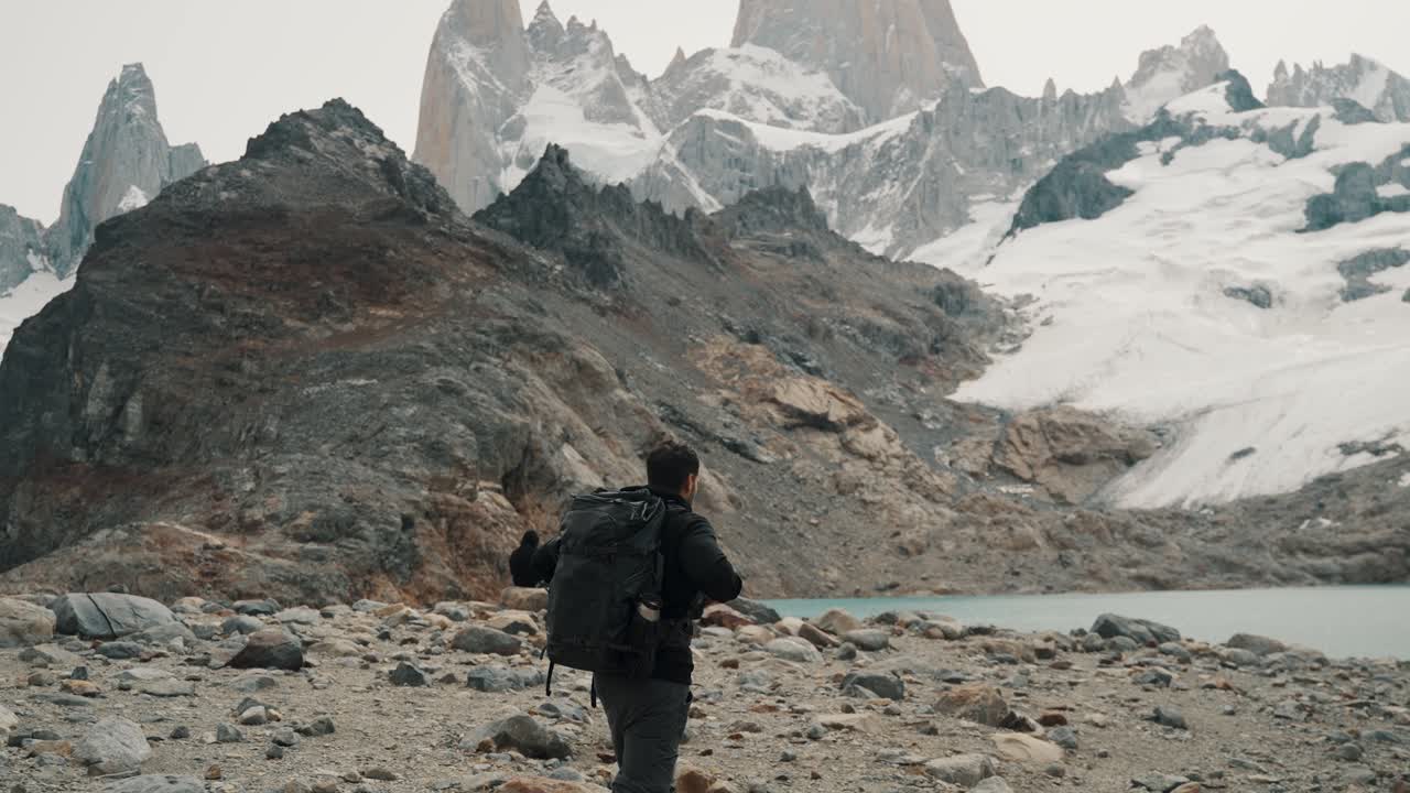Escursionisti che esplorano il terreno roccioso vicino a un lago glaciale con le splendide montagne Fitz Roy in Patagonia.