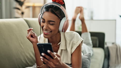 woman, phone and headphones for singing on sofa