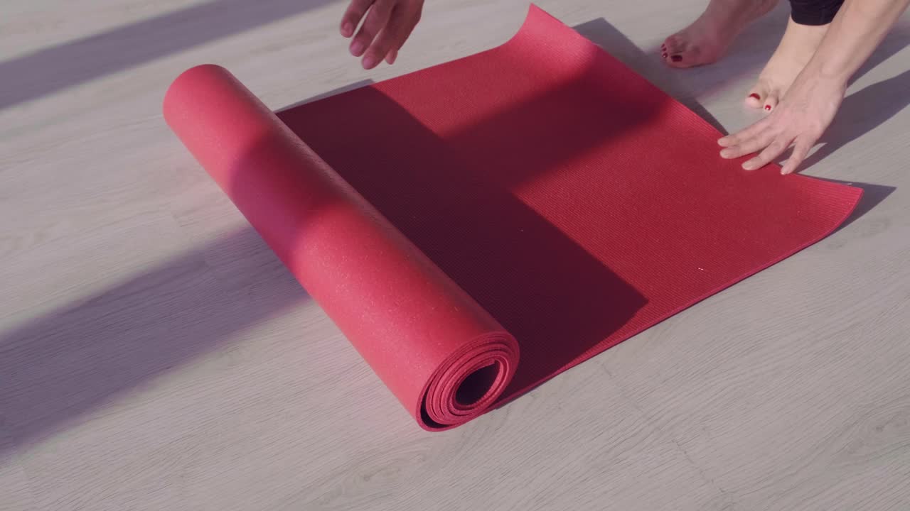 A Serene Start to Mindfulness: Unrolling a Yoga Mat in a Bright Room for Relaxation and Fitness Practice