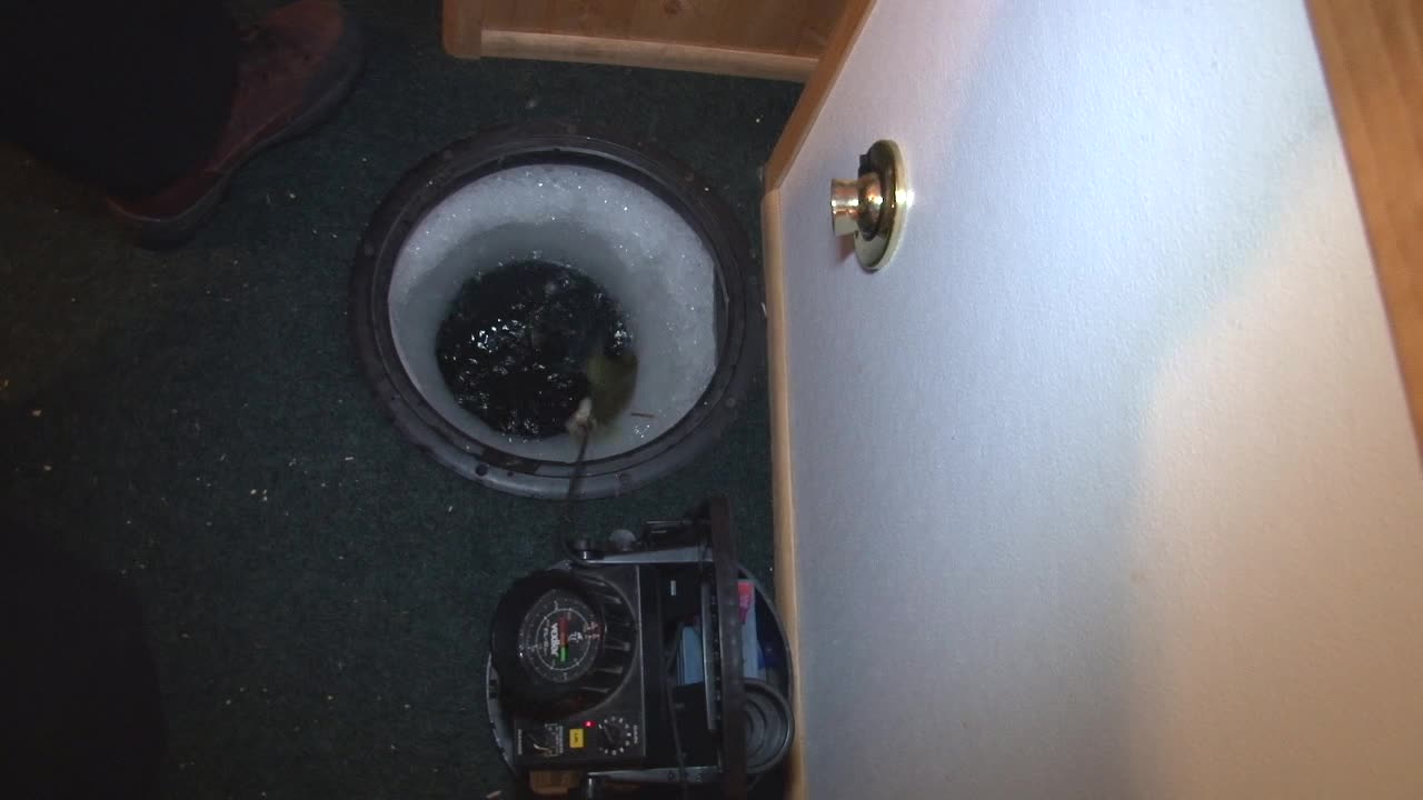 Fresh Caught Live Fish Flopping In Ice Hole. Ice Fishing With Innovative Ice Fishing Sonar System. high angle