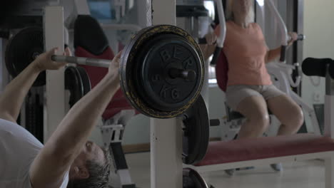 Hombre-Y-Mujer-Mayores-Haciendo-Ejercicio-En-El-Gimnasio