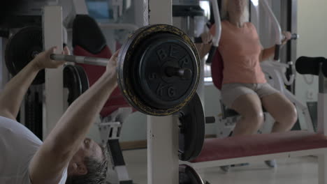 un hombre y una mujer mayores trabajando en el gimnasio.