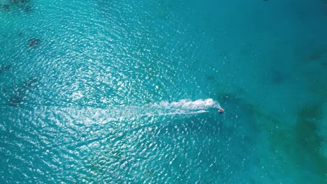 speedboat cutting through turquoise waters, top-down aerial view, sunny day