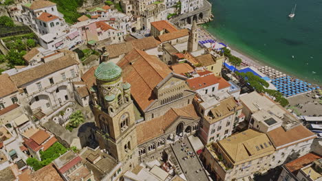 Amalfi-Italy-Aerial-v3-birds-eye-view-flyover-Piazza-Duomo-in-town-center-capturing-Cathedral-of-Saint-Andrew,-tilt-up-reveals-terraced-hillside-and-azure-sea-views---Shot-with-Mavic-3-Cine---May-2023