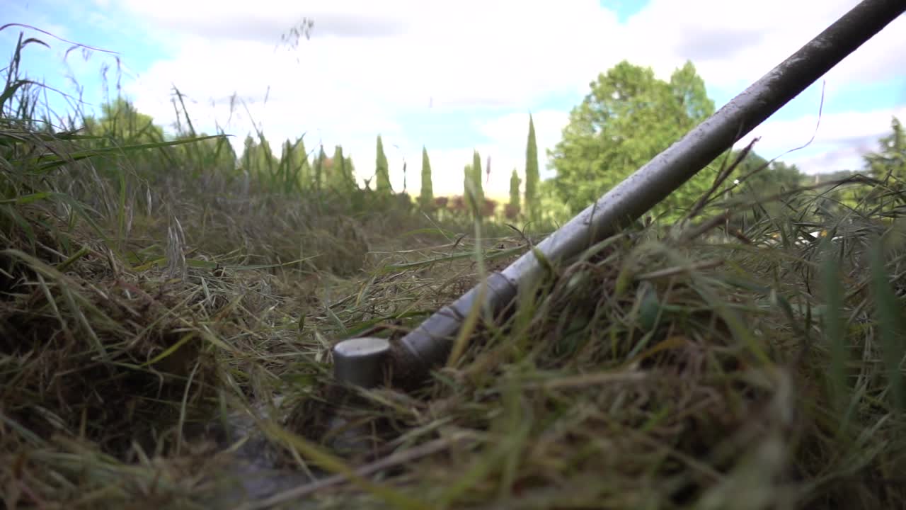 el jardinero corta las malezas, la hierba.