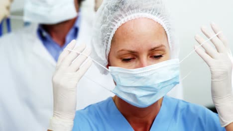 dentista y asistente dental con máscara quirúrgica