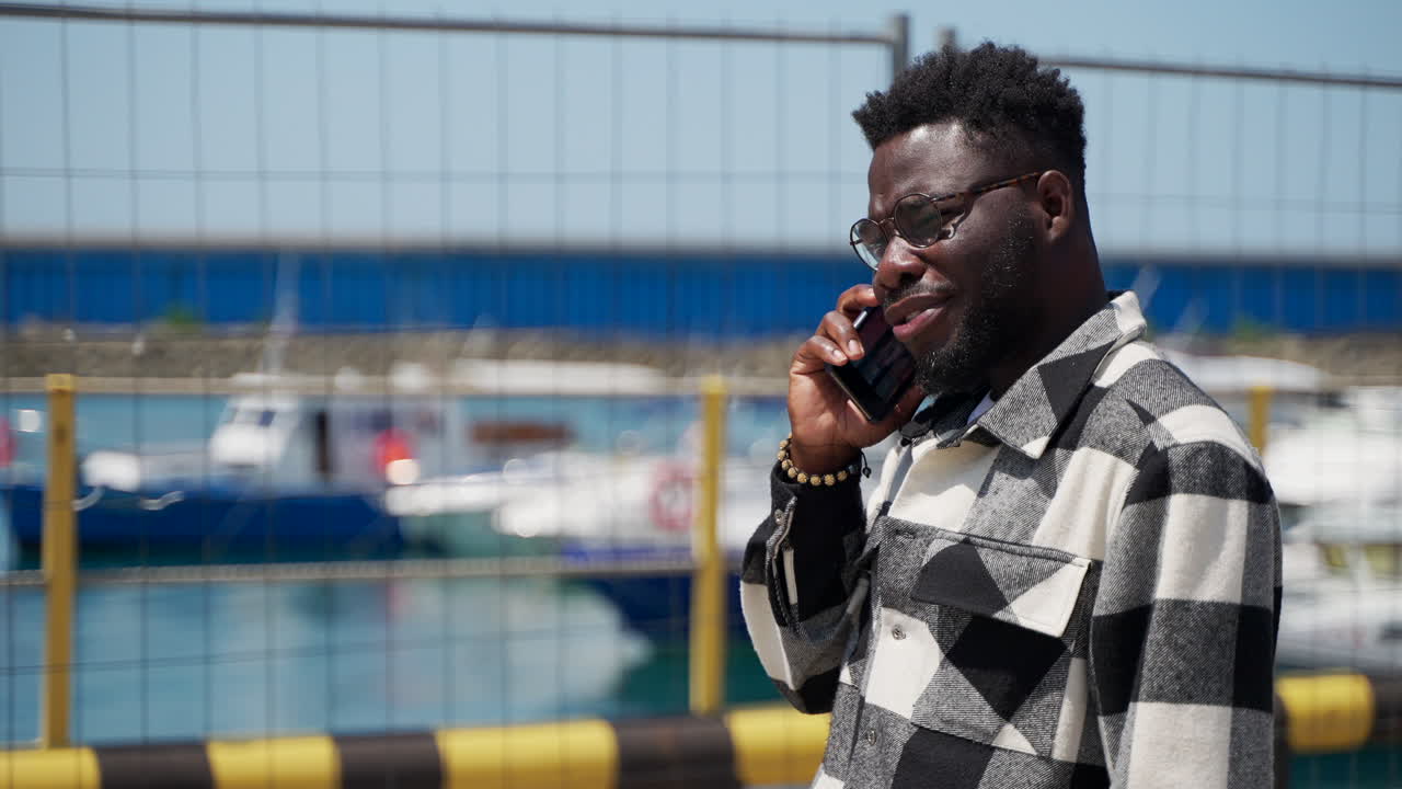 hombre hablando por teléfono en el paseo marítimo