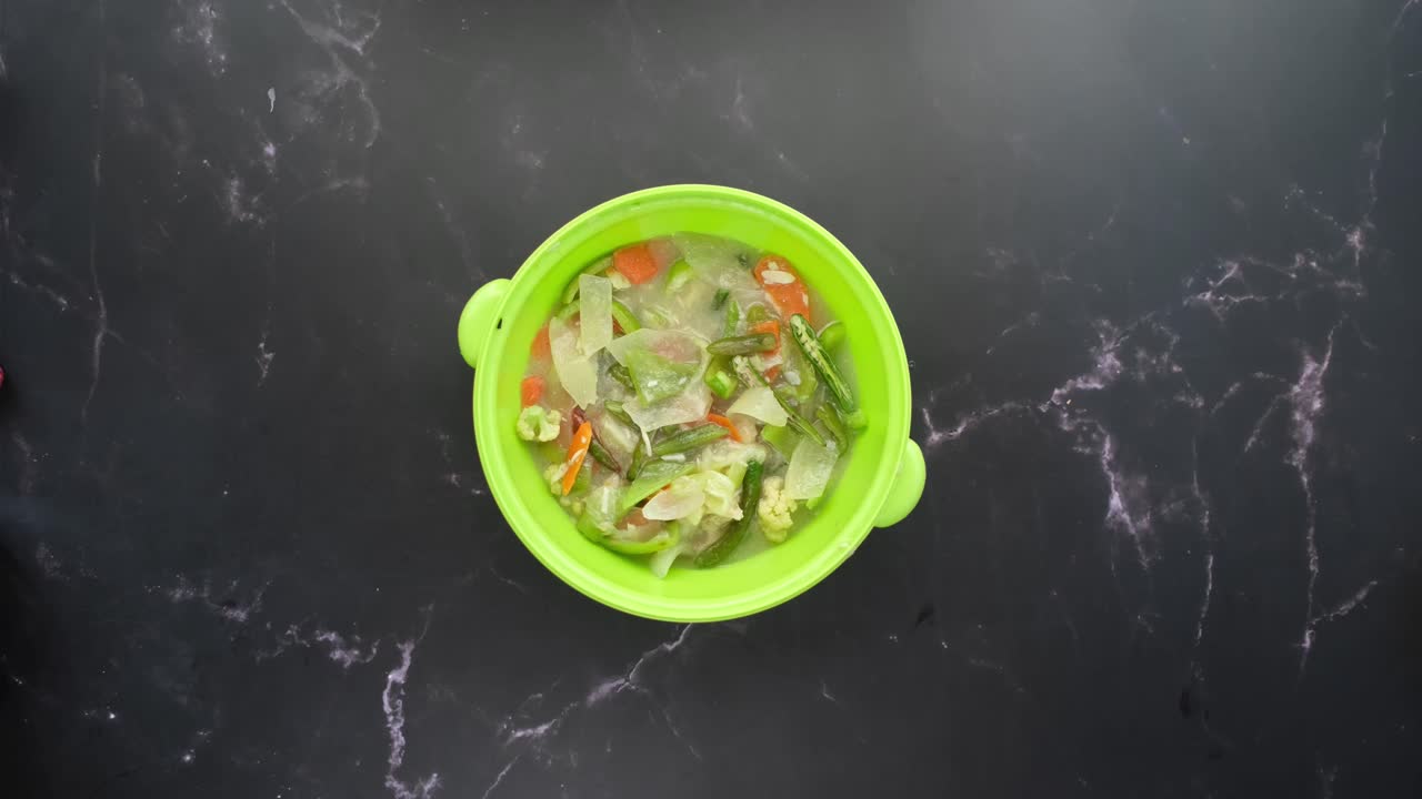 sopa de verduras en un cuenco verde