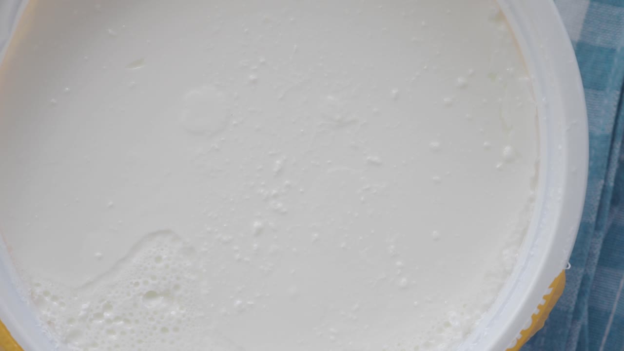 Close-up Overhead View of White Yogurt or Creamy Dairy Product in a Container