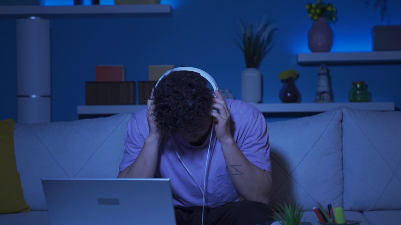 Young man thinking that he failed at home at night, angry with himself.