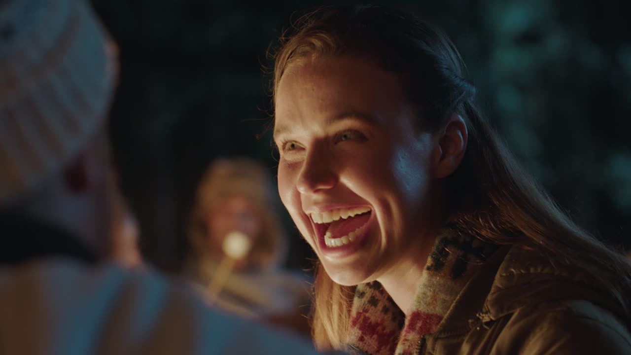 mujer feliz riendo charlando con un hombre conversando disfrutando de una conexión romántica coqueteando junto a una fogata 4k