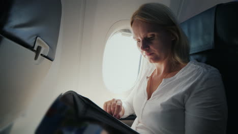 a young woman is reading a magazine in the cockpit of an airplane comfort and entertainment in the j