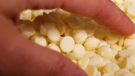 hands interacting with white chocolate chips