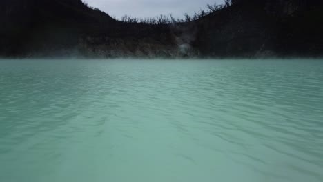 white crater kawah putih with low aerial drone over lake in indonesia