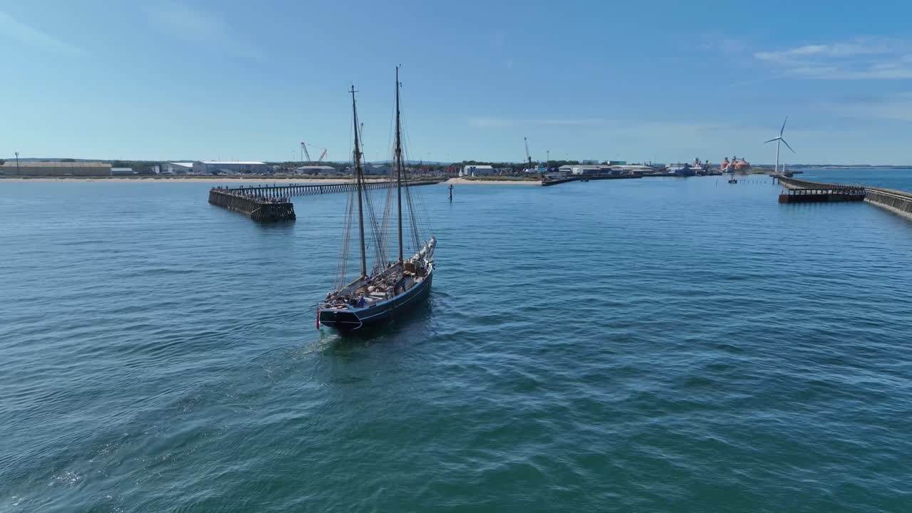 Traditional Tall Ship entering Blyth Harbour with industrial area seen in the background