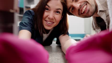 First-person-view-of-a-happy-girl-veterinarian-in-a-blue-uniform-together-with-the-owner-of-a-pet-taking-it-out-of-a-special-carrier-in-a-veterinary-clinic