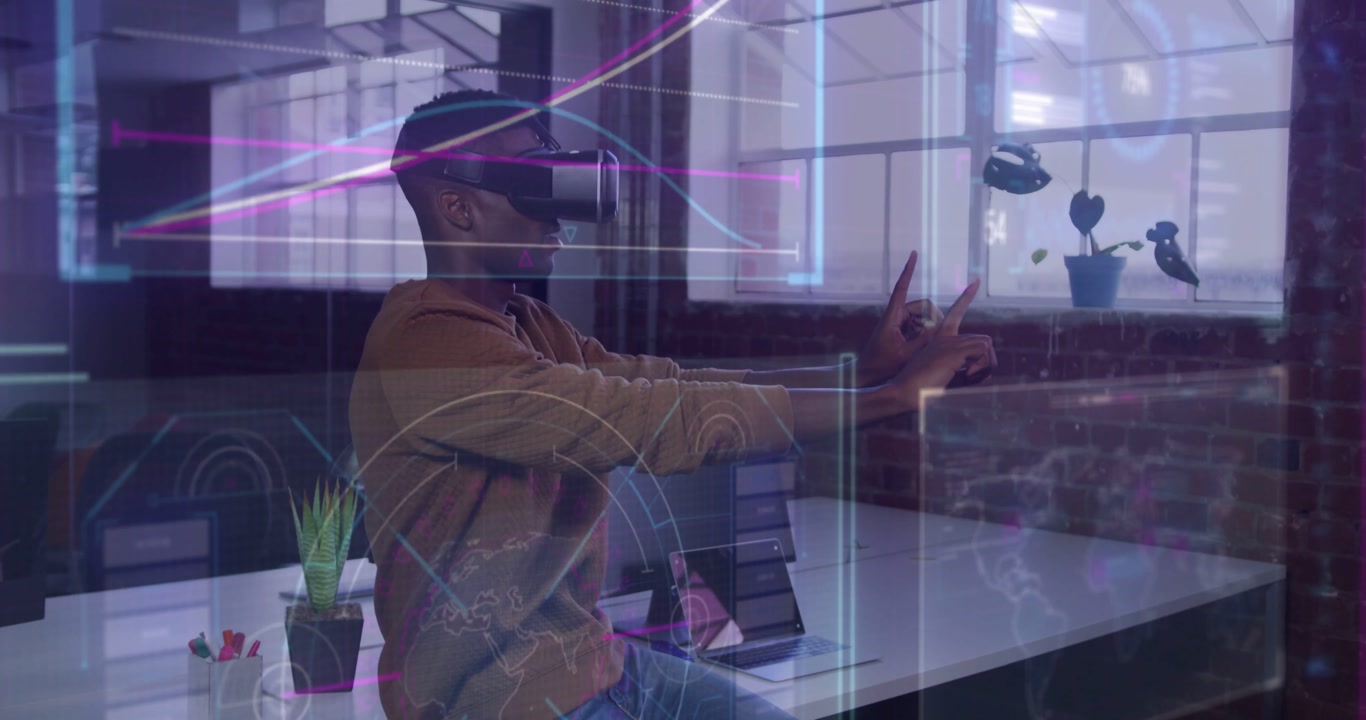 Man wearing VR headset at desk overlays appearing tapping charts and icons refining tech interface