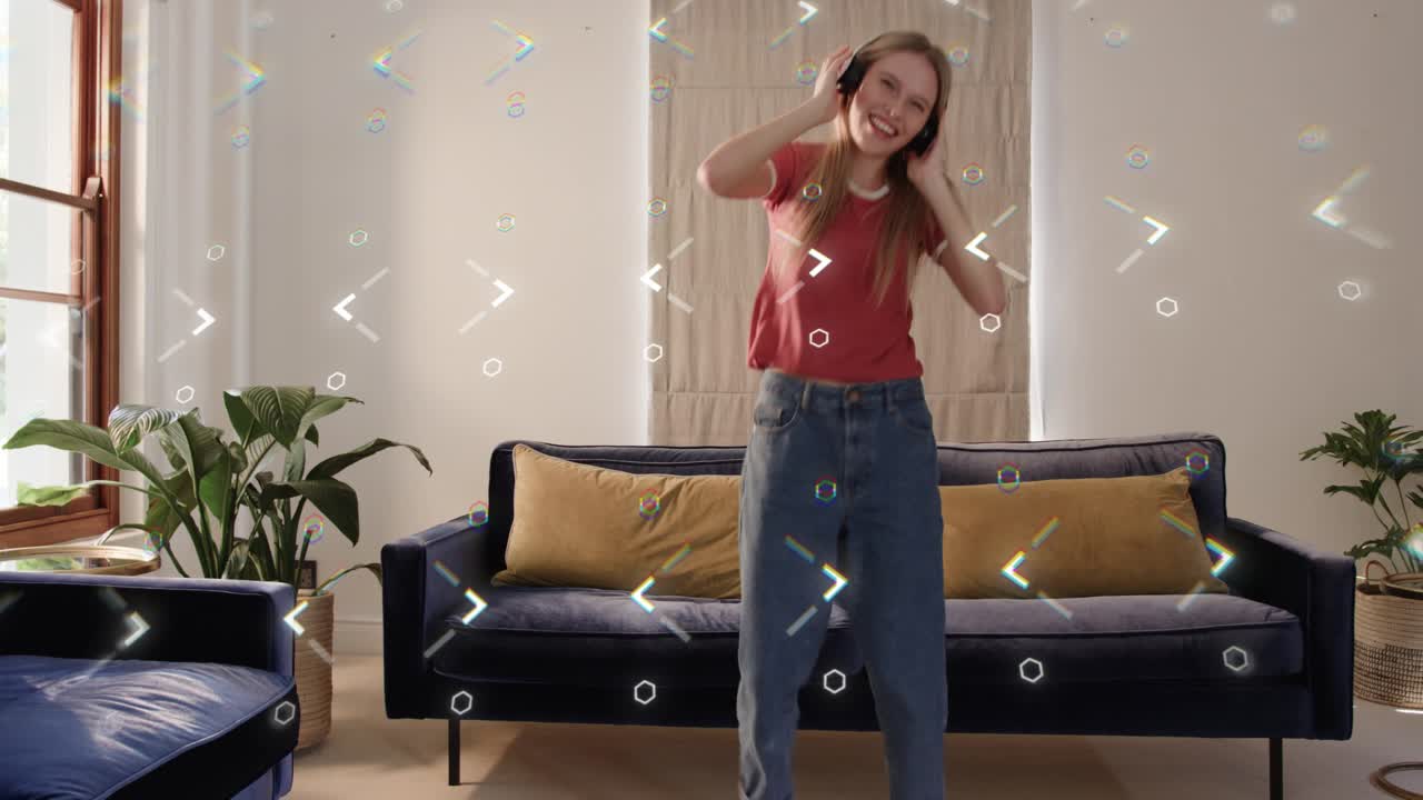 Woman placing headset, starting dancing to music in living-room, hexagon overlaying, obscuring her