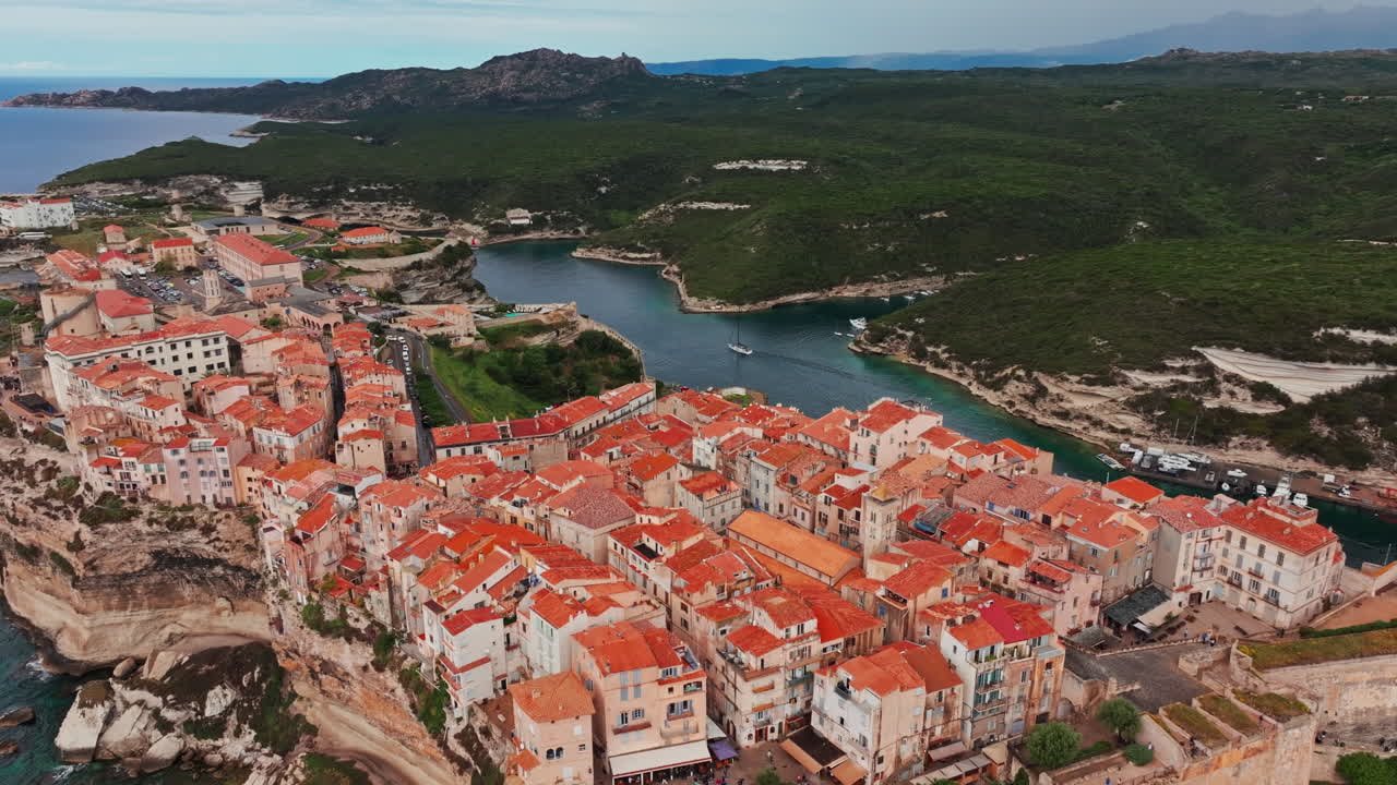 Ripresa aerea con drone della storica città costiera di Bonifacio in Corsica, Francia. Vista dall'alto della ripida scogliera rocciosa e del mare turchese. Antica cittadella con vista sulla costa frastagliata