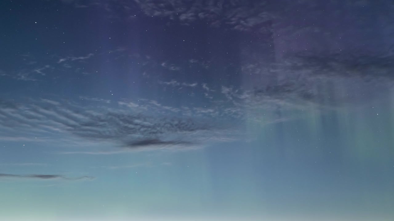 夜空にかすかにきらめくオーロラと星々