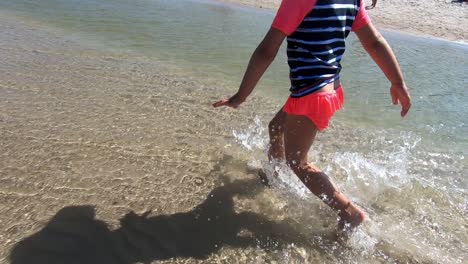 little girl walking in shallow water splashing