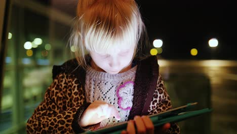 Ein-Mädchen-Genießt-Das-Tablet-Auf-Dem-Hintergrund-Eines-Großen-Fensters-Mit-Reflexionen-Reflection